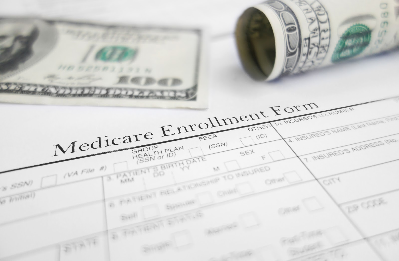 Medicare enrolment form with money bills in the background