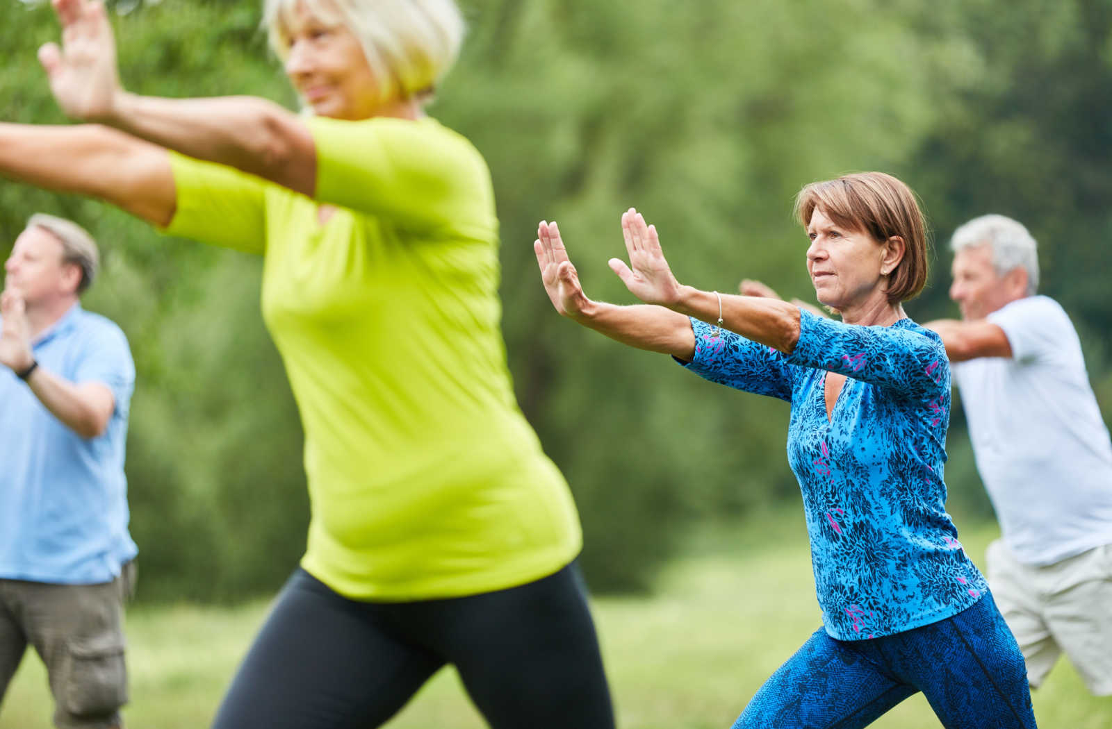 A group of adults doing tai chi outdoors.
