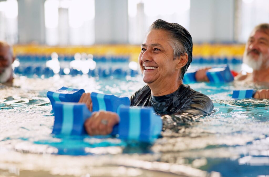A senior participates in a water aerobics class as a form of low-impact exercise to help improve their strength and mobility.