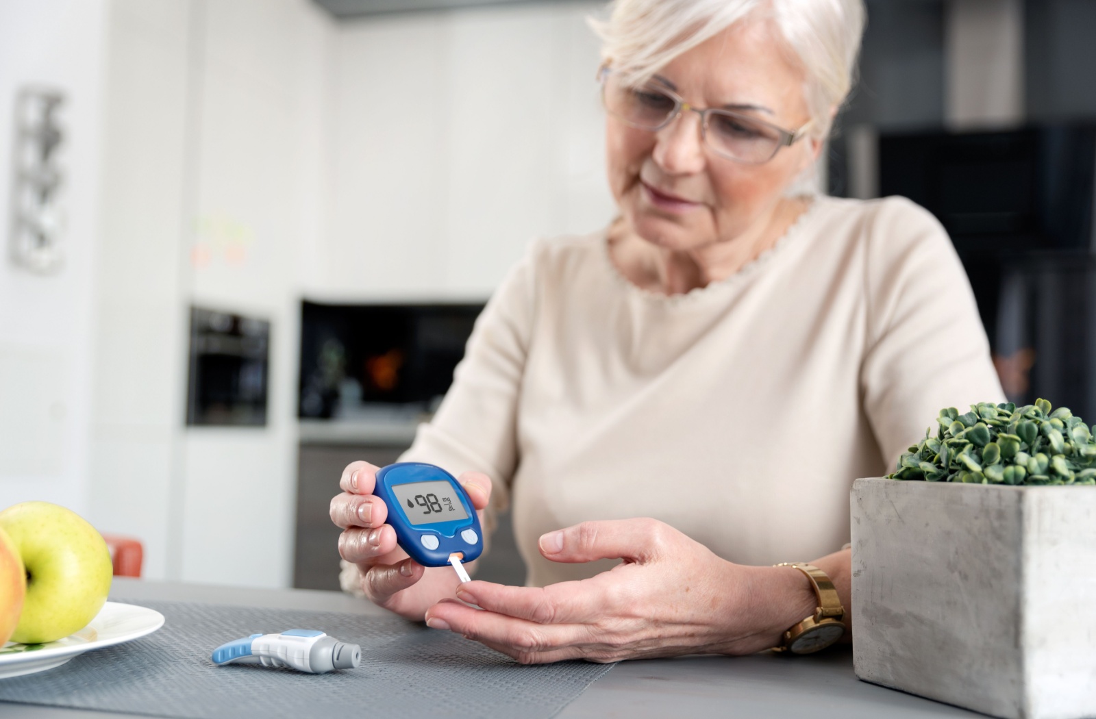 An older adult tests their blood sugar level using a glucometer.