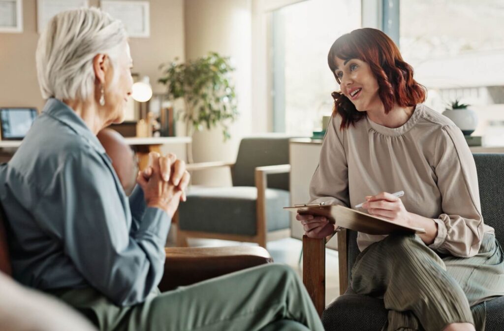 An older adult meets with a health professional to discuss their symptoms.