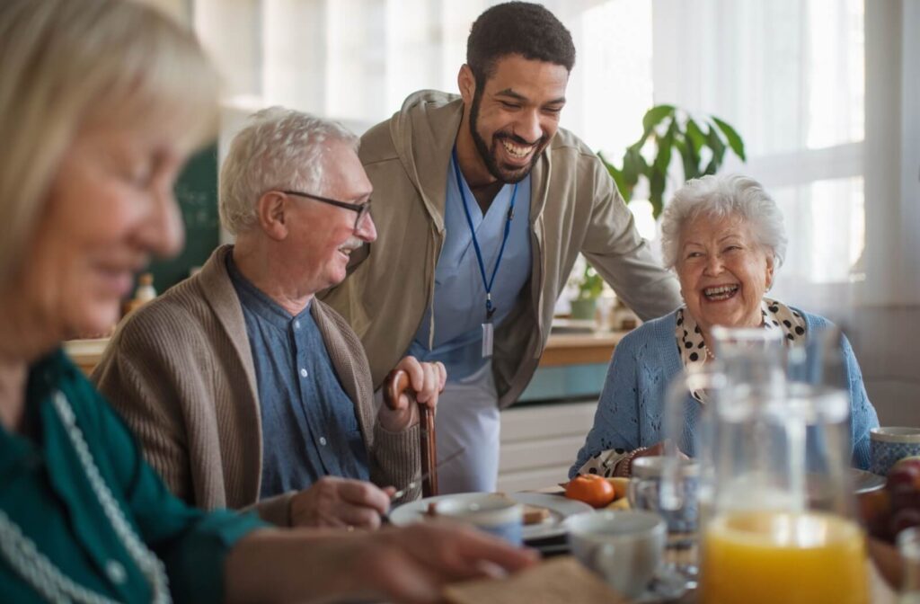 Older adults are being cheerfully served their meal in a dining hall.